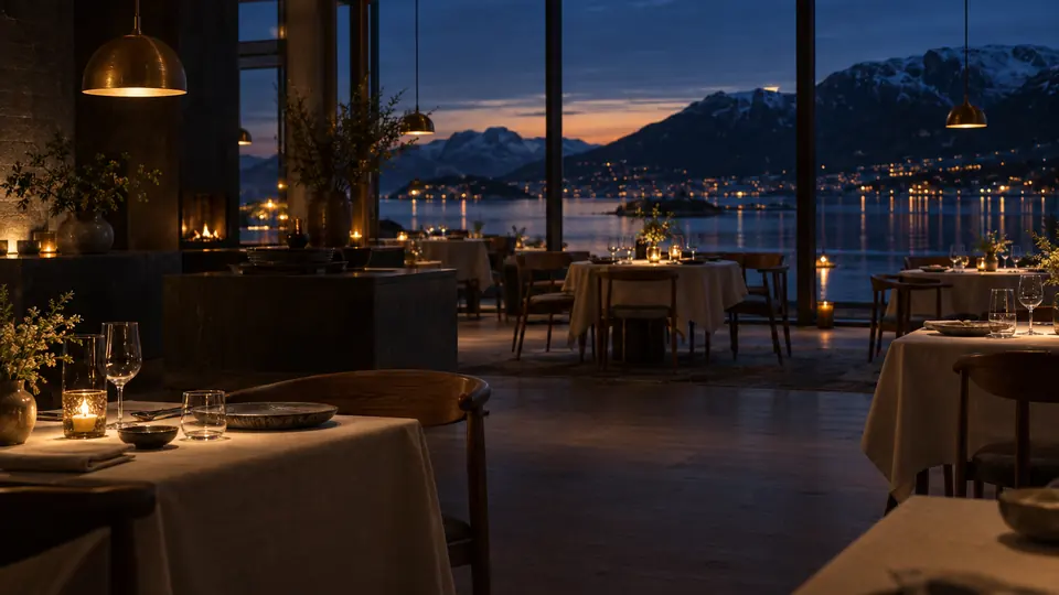 Spisesalen i Salt og Lyng ved blå time, med levende lys og utsikt mot fjorden